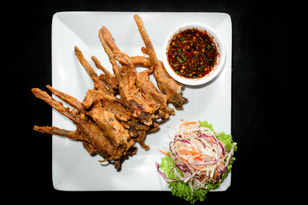 Fried duck mouth, Dish of deep fried seasoning duck mouth on black backgroundの写真素材