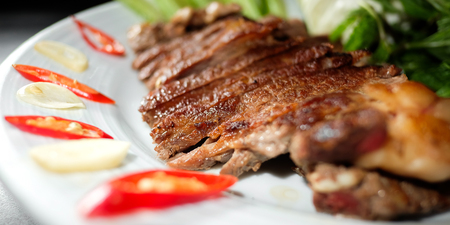Roasted pork with vegetables in black backgroundの写真素材
