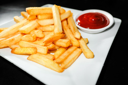 a pile of appetizing french fries on a black background