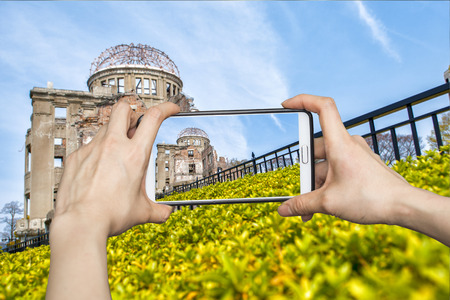 Girl taking pictures on mobile smart phone in atomic bomb,hiroshima,Japanの写真素材