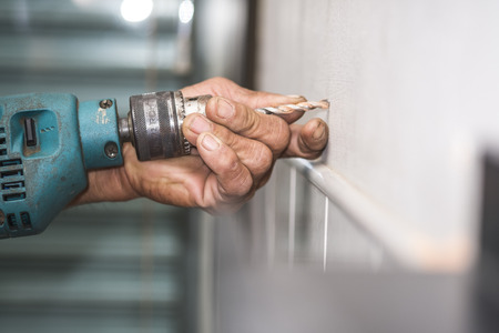 hands hold electric drill in room , interior design and home renovatioの写真素材
