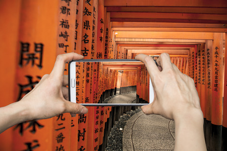 Girl taking pictures on mobile smart phone in Tori gate,Hiroshima,Japanのeditorial素材
