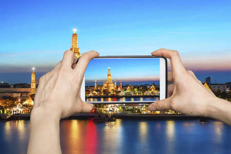 Girl taking pictures on mobile smart phone in Wat Arun,bangkok, Thailand