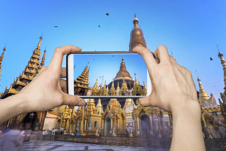 Girl taking pictures on mobile smart phone in Shwedagon Pagoda , Myanmarの写真素材