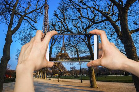 Taking pictures on mobile smart phone in The Eiffel tower is the most visited monument of France.の写真素材
