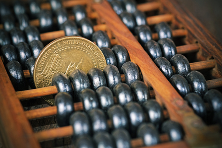 vintage wooden abacus with coin on wood backgroundの写真素材