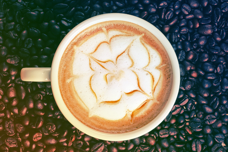 Capucino art coffee on Coffee beans backgroundの写真素材