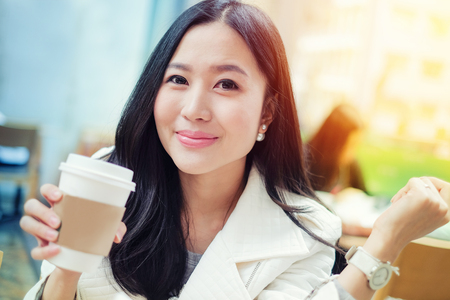 Woman drinking coffee at restaurant with sunrise streamingの写真素材