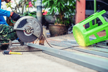 The man working on cutting a metal and steel with compound mitre sawの写真素材