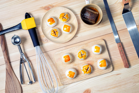 Chinese pastry moon cake with cup of tea and baking toolsの写真素材