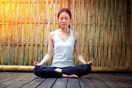 Young beautiful woman meditating in nature bamboo backgroudの写真素材