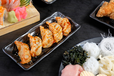 Gyoza and spicy sacue on black diseの写真素材