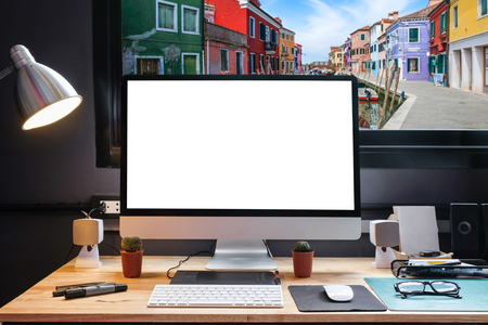 Graphic designer's workspace with a pen tablet, a computer and white backgroud for text with beautiful view of burano from Window の写真素材