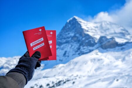 KLEINE SCHEIDEGG - 27 MARCH : Tourists see beautiful viewpoitn near Kleine Scheidegg station and showing Jungfraujoch red pass and snow mountain background at 27 March 2017, Switzerlandのeditorial素材