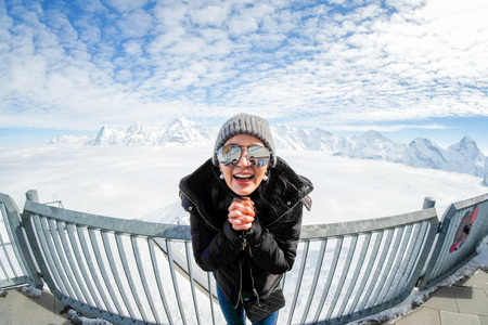 Young Woman Tourist at the Schilthorn in Switzerland with a magnificent panoramic view of the Swiss...
