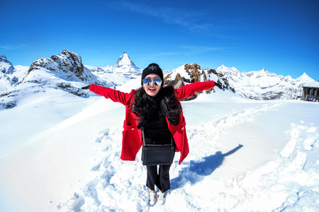 Young Woman Tourists see beautiful view of snow mountain Matterhorn peak, Zermatt, Switzerland.