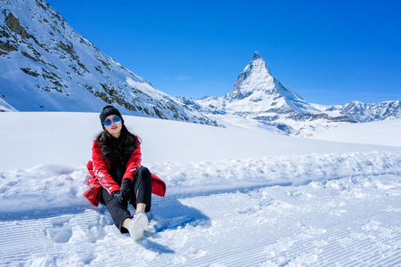 Young Woman Tourists playing snow in mountain Matterhorn peak, Zermatt, Switzerland.の写真素材