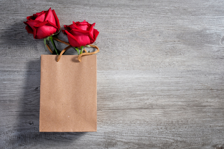 Happy Valentine's Day Concept with red roses in paper bag and space for textの写真素材