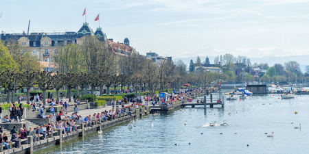 ZURICH, SWITZERLAND - 31 MARCH: People sitting on the stairs to Lake Zurich and enjoying a sunny day in Zurich, Switzerlandのeditorial素材