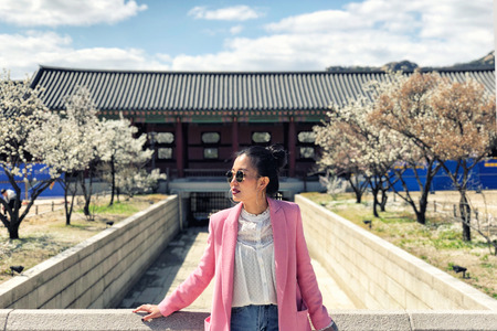 Young beautiful woman visiting the beautiful Gyeongbokgung Palace, Seoul, South Korea on a sunny dayの写真素材