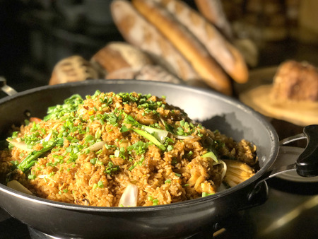Garlic fried rice with vegetables on top and bread backgroundの写真素材