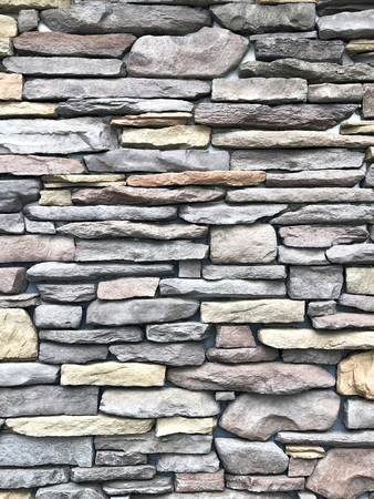 Rock wall pattern gray color of modern style design decorative uneven cracked real stone wall surface with cementの写真素材