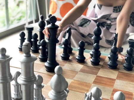 Close up of hands of young  woman playing chess.の写真素材