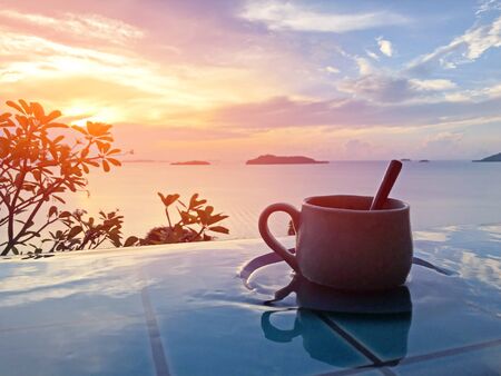 Vintage cup of hot coffee  beside the pool in morning viewの写真素材