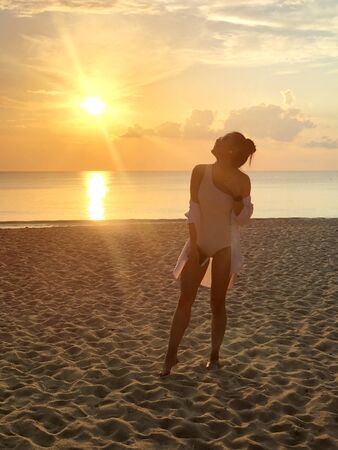 Happiness woman on beach. She is enjoying serene ocean nature sunset during travel holidays vacation outdoors. at phuket Thailandの写真素材