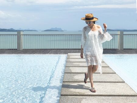 Summer holidays and vacation - Happy woman on the pool side in Phuket, Thailandの写真素材
