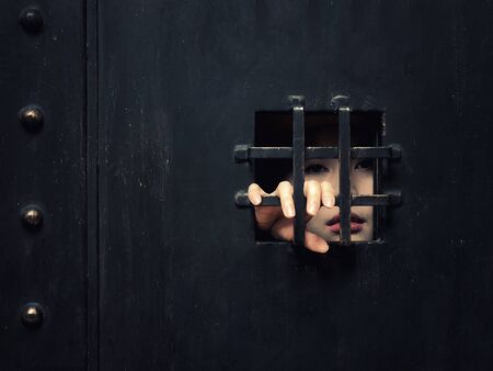 Horror woman locked in dark cage hand holding cage scary scene halloween conceptの写真素材