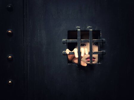 Horror woman locked in dark cage hand holding cage scary scene halloween conceptの写真素材