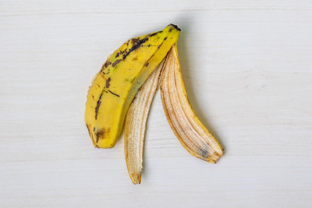 Yellow ripe banana skin on a wooden background. Top view.の写真素材