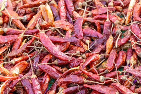 A background of dried red hot chili peppers. These dried peppers, a flavorful condiment and spice,...