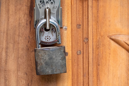 Close-up of an old, unlocked door lock on a wooden door.の写真素材