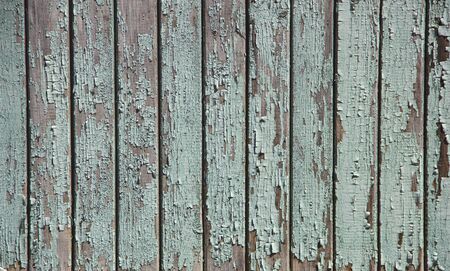 the fence of the boards painted green in some places the paint swelled and falls offの写真素材