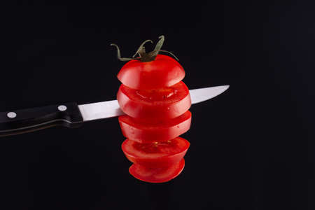 tomato in the air cut with a knife