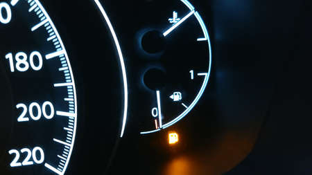 a low fuel level icon is lit on the dashboard in the carの写真素材