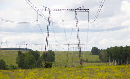 high power poles stand in a green field