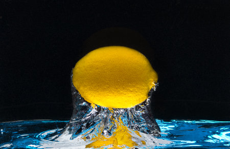 lemon with streams flies out of the waterの写真素材