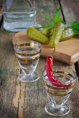 two glasses of vodka and pickles on the tableの写真素材