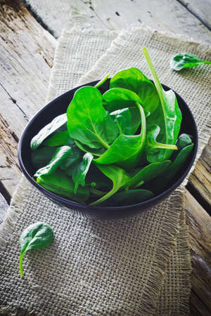 spinach leaves in a bowl on the tableの写真素材