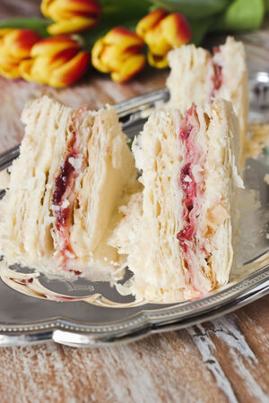 cake with cranberry jam, cream and tulips