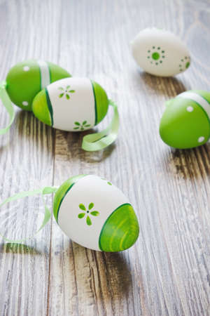 painted easter eggs with ribbons on a wooden backgroundの写真素材
