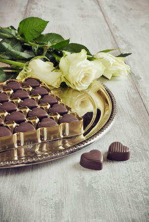 chocolate candy in the form of hearts and roses on a metal plateの写真素材