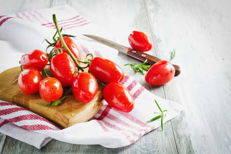 bunch of ripe tomatoes on a wooden cutting board. selective focusの写真素材