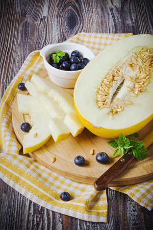 fresh melon and blueberries on a wooden cutting board. selective focusの写真素材