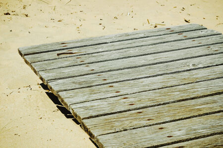shield of wooden boards lying on the sand. copy space background