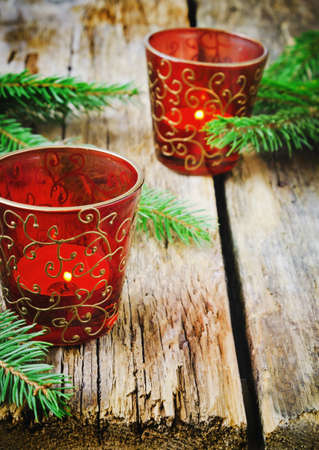 christmas candles in the beautiful christmas glasses on the old wooden background.の写真素材