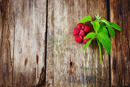 tasty ripe raspberries on the old wooden background.
